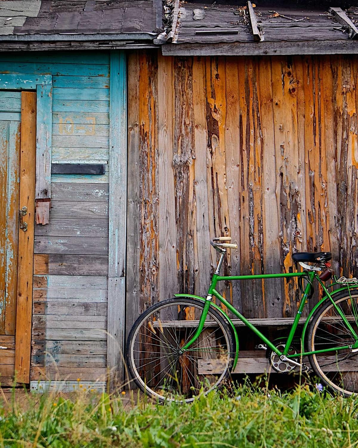La façade en bois de l'atelier, un vélo vert posé devant